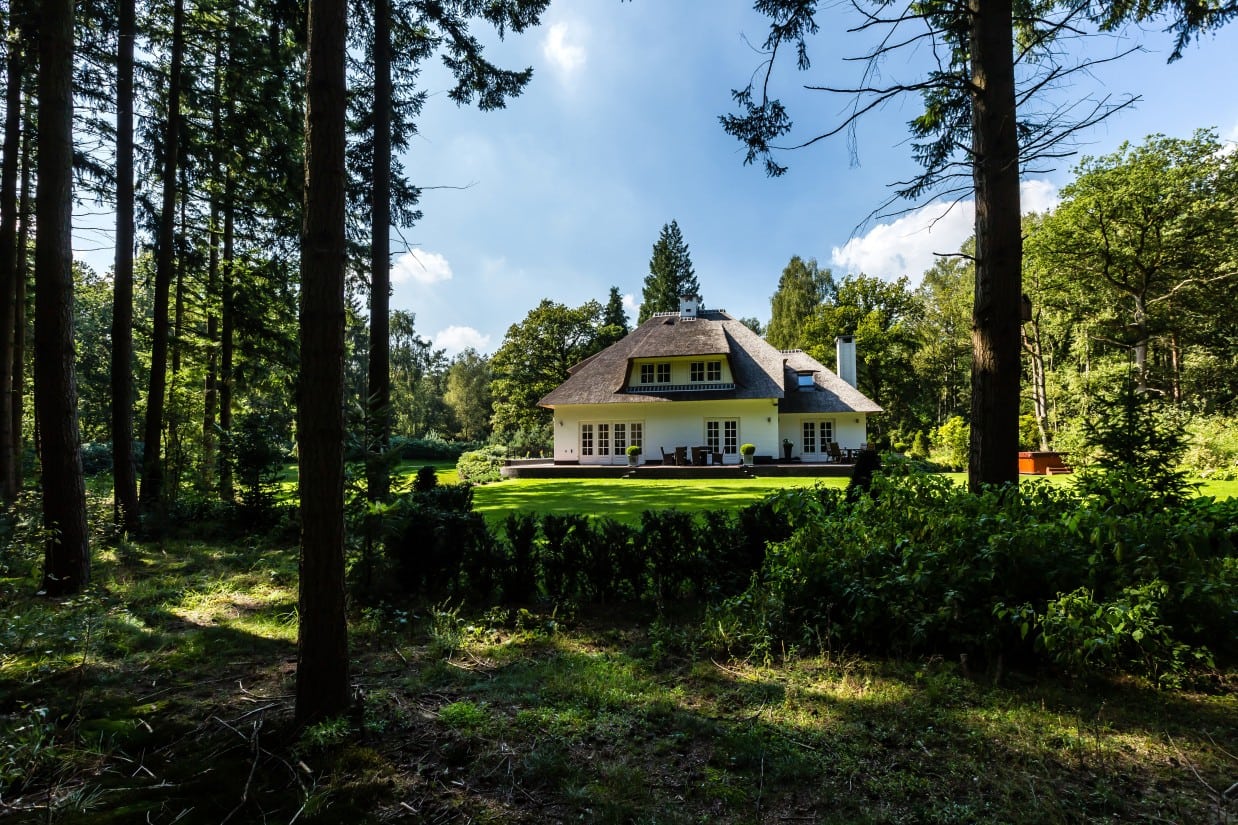 Rietgedekte villa bouwen, landhuis gelegen in bosgebied